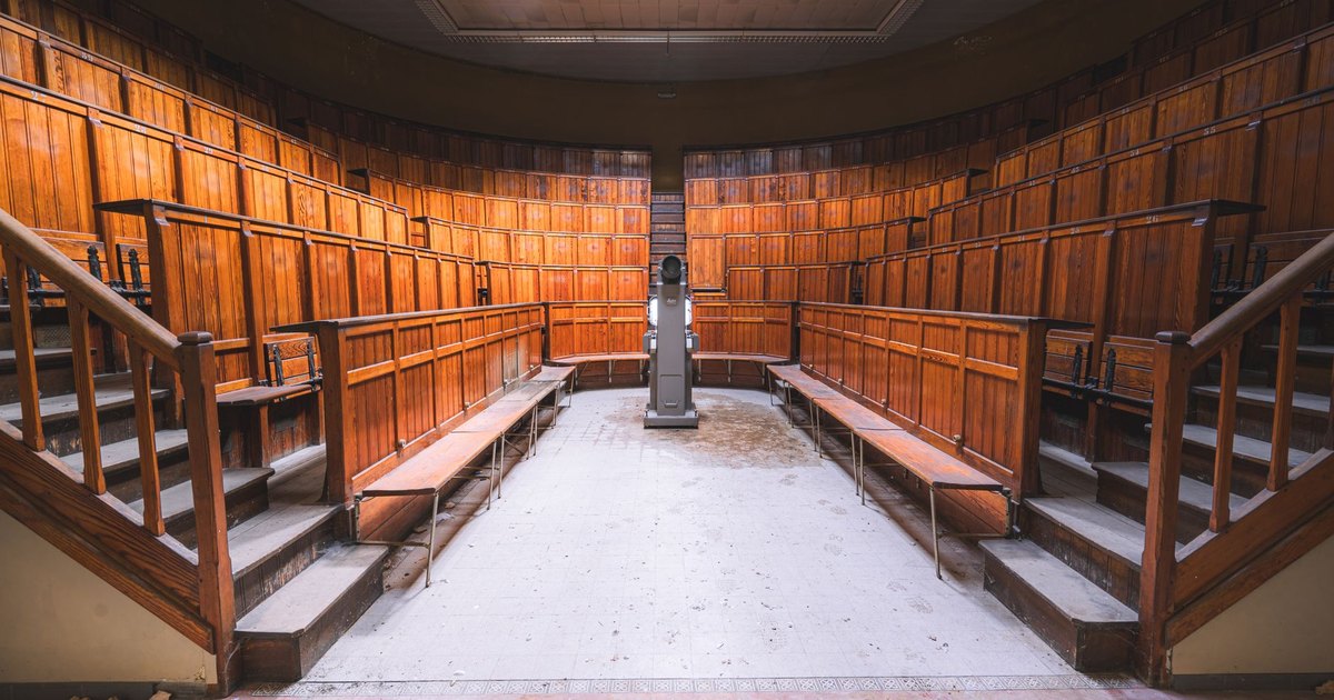Empty wood-paneled courtroom interior with a judge's bench