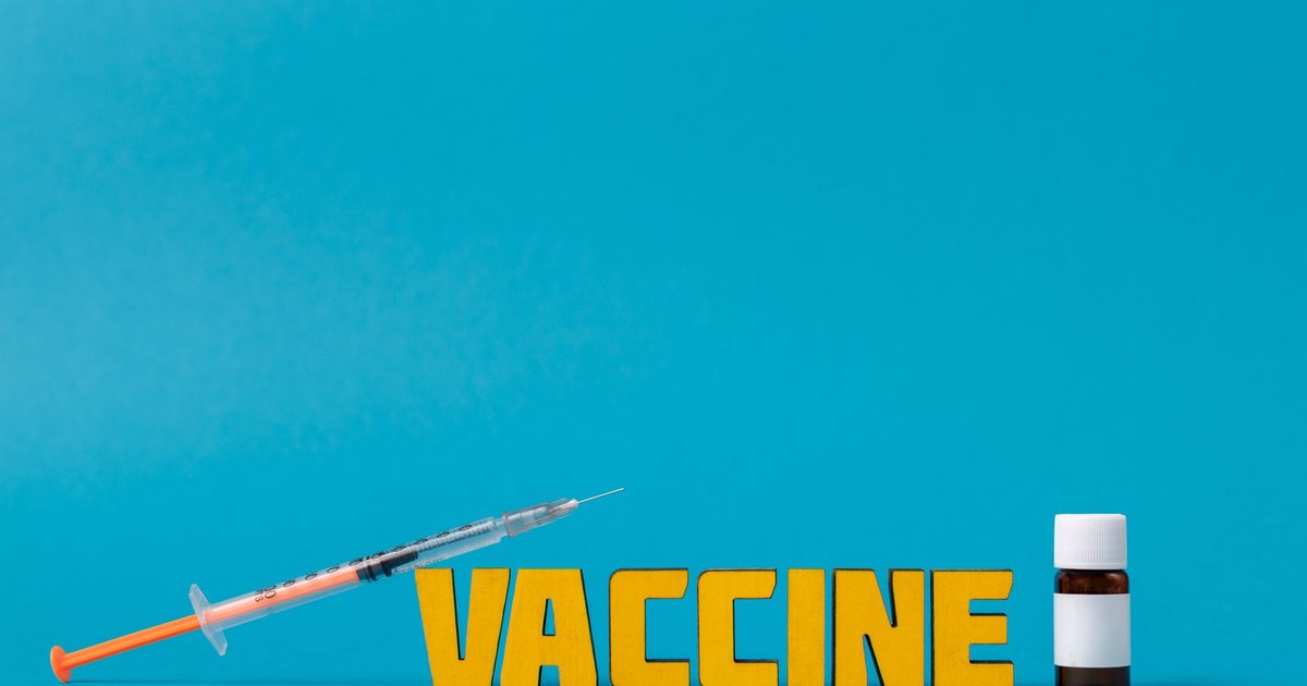 Vials of vaccine and a syringe on a medical tray