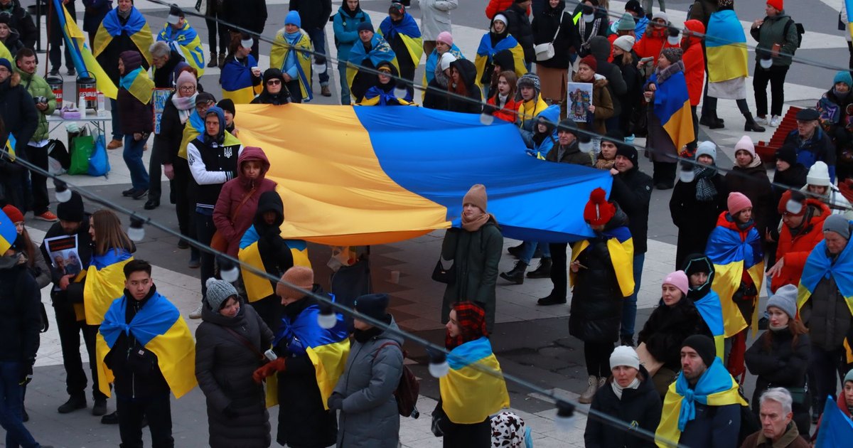 Silhouetted marchers carrying flags at dusk